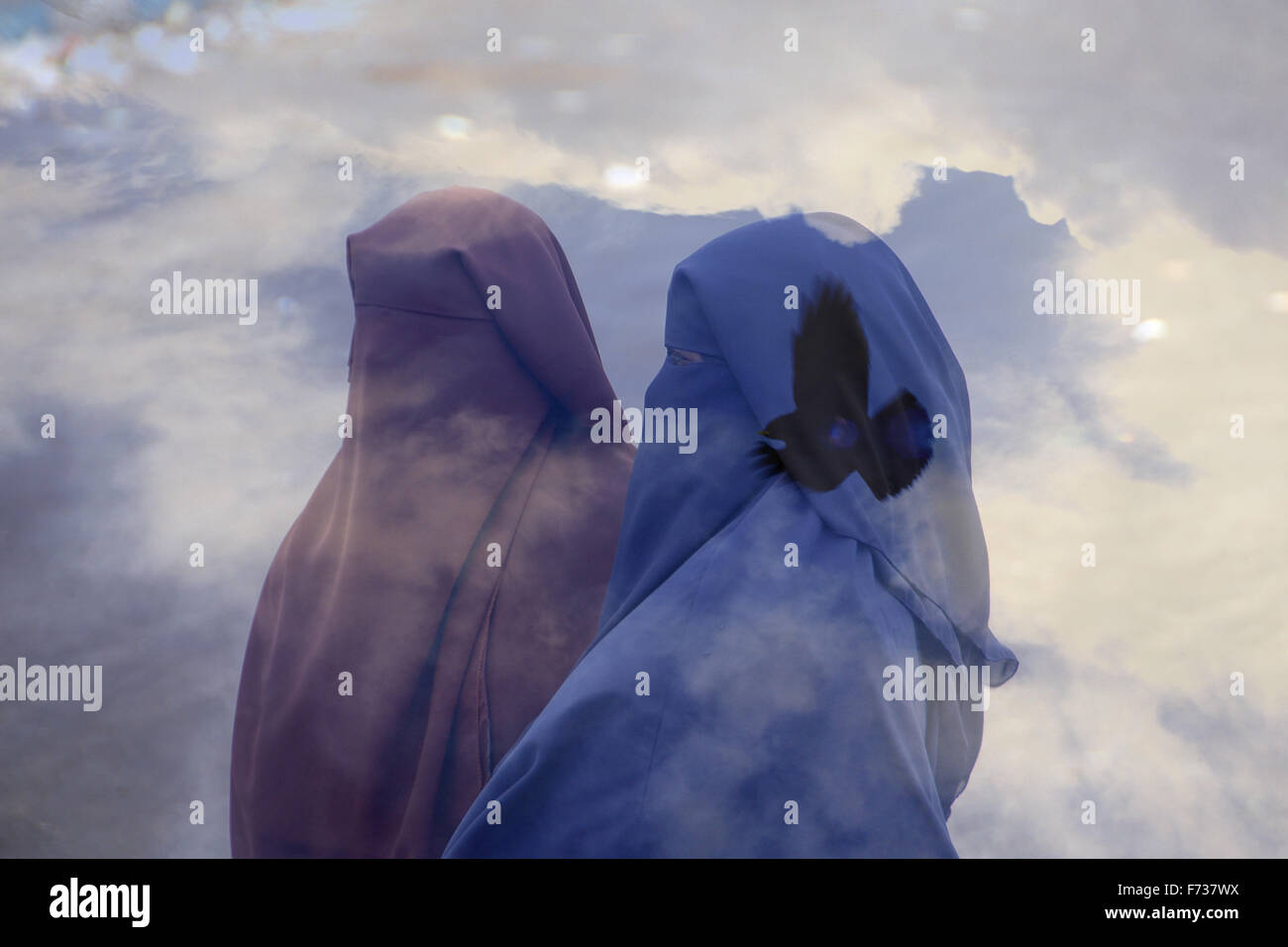 Doppelbelichtung der muslimischen Frauen das tragen voller Niqab Schleier und ein Vogel fliegt in den Himmel Stockfoto