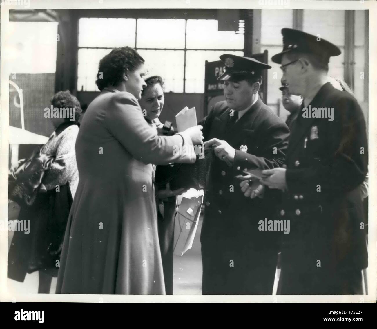 1964 - Spot Recherchen sind häufig von Zollbeamten an den Piers durchgeführt, wo die Schiffe anlegen. Das Bild zeigt ein Zollbeamter fragt Frau Passagier, öffnete ihre Handtasche, die nach dem Zufallsprinzip angehalten wurde, wenn Sie eine eingehende Liner aus Europa zu verlassen. Das könnte jedem passieren, denken die meisten Frauen Passagiere, die Zoll-Männer sind auf der Suche nach eine Flasche Parfüm oder Nylons, aber es geschmuggelten Drogen sind sie ist nach. © Keystone Bilder USA/ZUMAPRESS.com/Alamy Live-Nachrichten Stockfoto