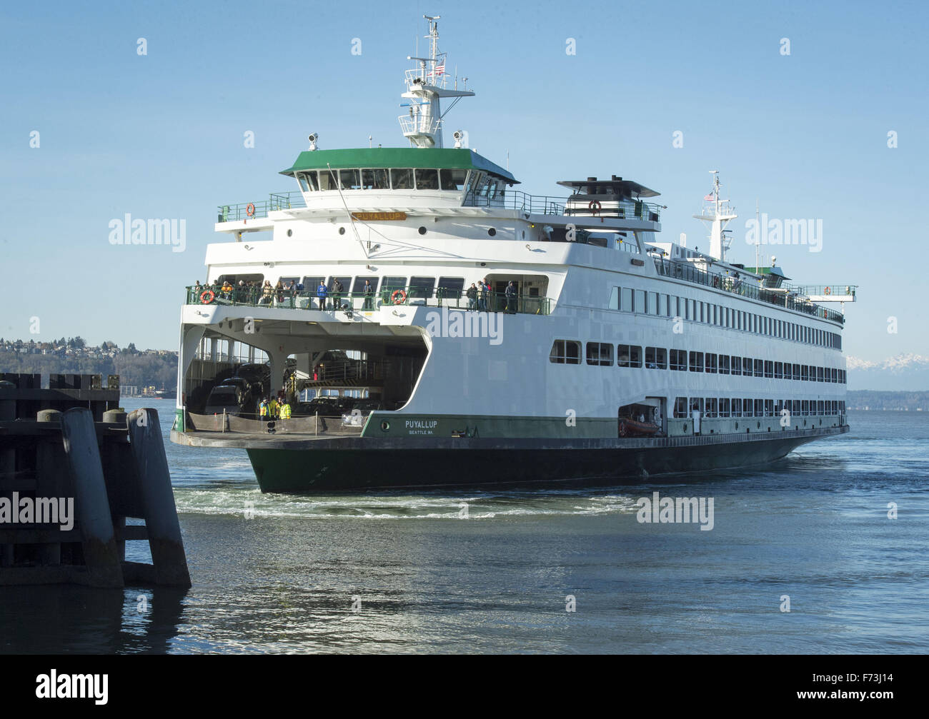 Seattle, Washington, USA. 21. November 2015. Die Washington State Ferry System, unter dem Department of Transportation betreibt etwa zwei Dutzend speziell Fähren auf 10 verschiedenen Routen auf 20 verschiedenen Terminals befindet sich in Puget Sand und den San Juan Islands. Im Rahmen des Washington State Highway Systems ist optisch unverwechselbaren grüne und weiße lackierte Rumpf erkennbar. ---Auf dem Foto eingehende MV Puyallup Ansätze der Seattle terminal aus Bainbridge Island mit der Olympic Bergkette sichtbar in der Ferne. © David Bro/ZUMA Draht/Alamy Live-Nachrichten Stockfoto