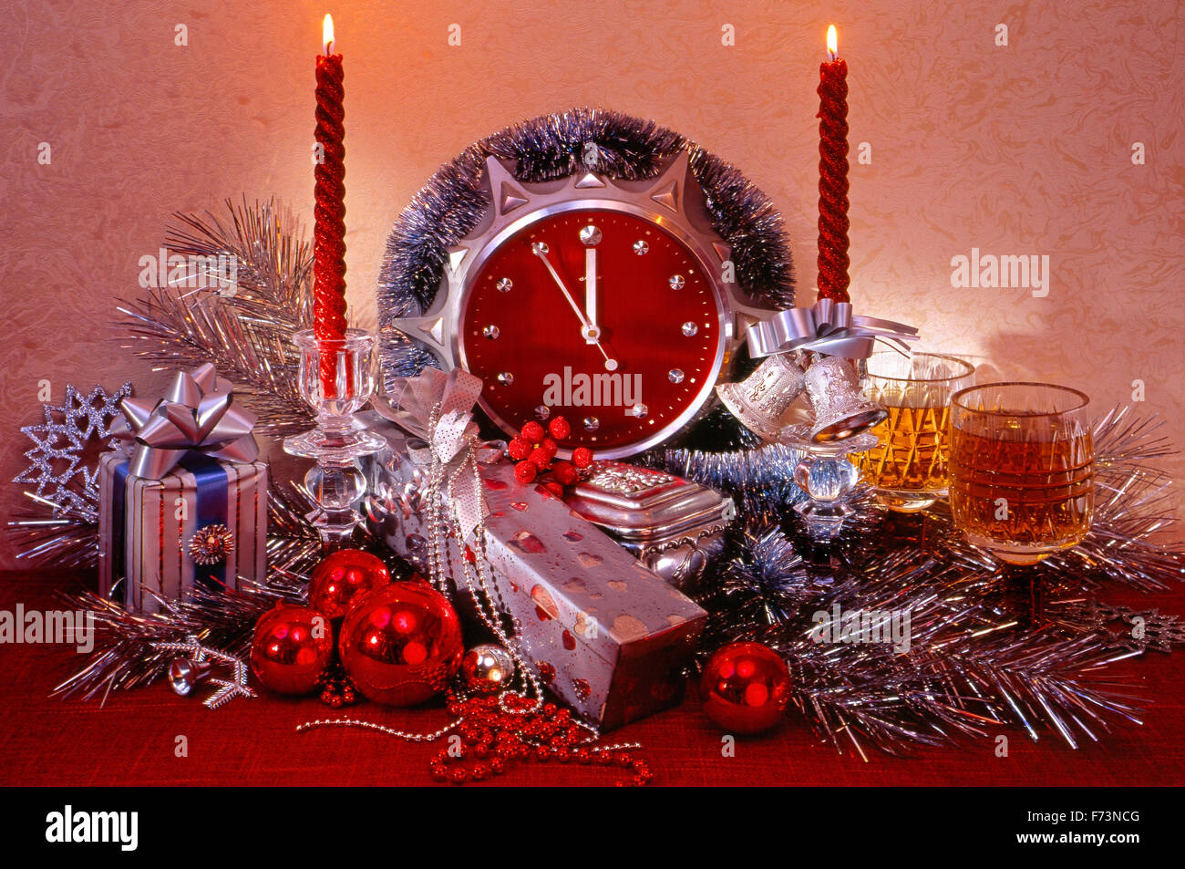 Festliches Silvester, Weihnachten Stilleben in hellen rosa Tönen mit Stunden, und auch mit zwei Gläser mit Wein, Stockfoto
