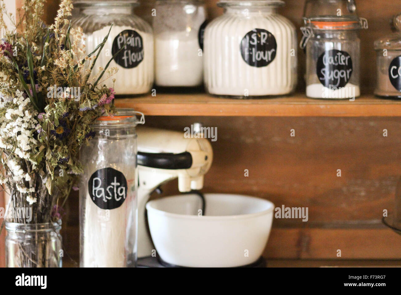 Backzutaten auf eine antike Küche Stall angezeigt. Eine stilvolle Möglichkeit zum Speichern Ihrer Grundnahrungsmittel wie Mehl, Zucker usw.. Stockfoto