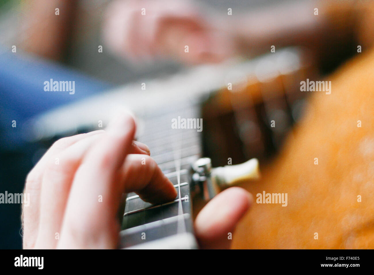 Extreme Nahaufnahme von den Händen der männlichen Banjo-Spieler auf die Bünde. Stockfoto