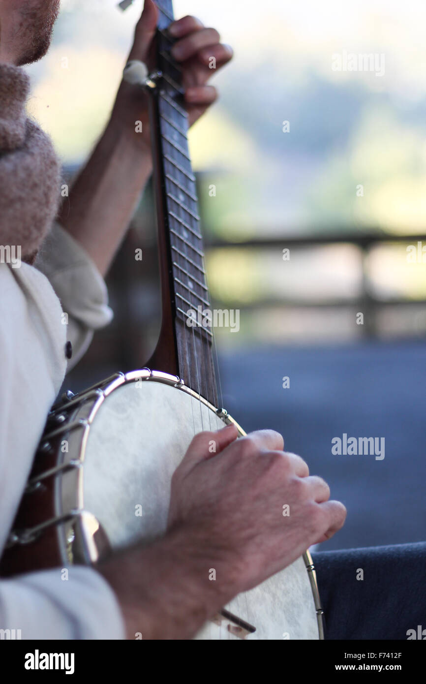 Banjo-Spieler üben einige Songs im Morgenlicht, in einer ländlichen Umgebung. Stockfoto