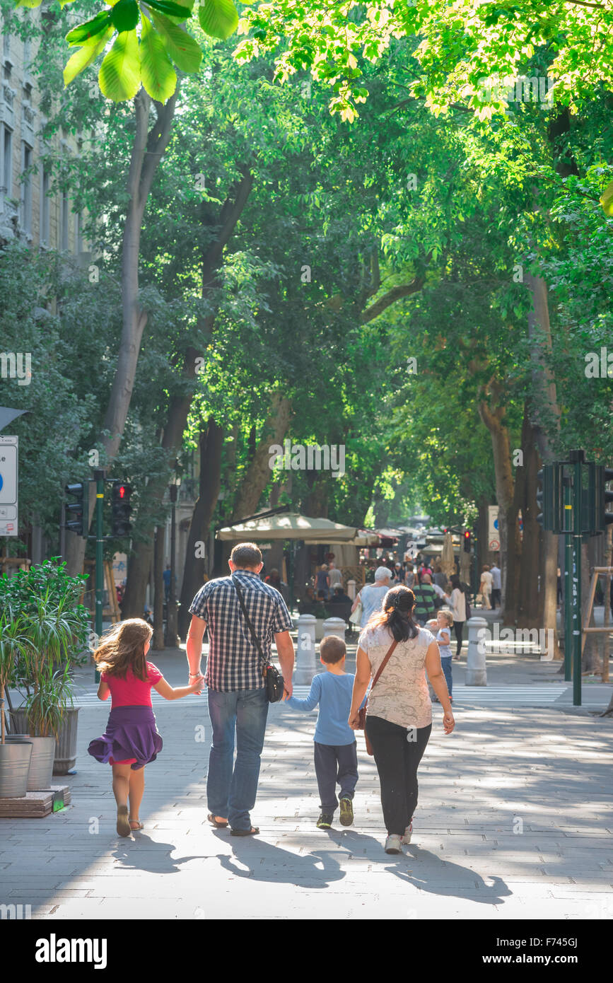 Familie gemeinsam an einem Sommermorgen eine Familie Fuß entlang der Viale XX Settembre im Zentrum von Triest, Italien. Stockfoto
