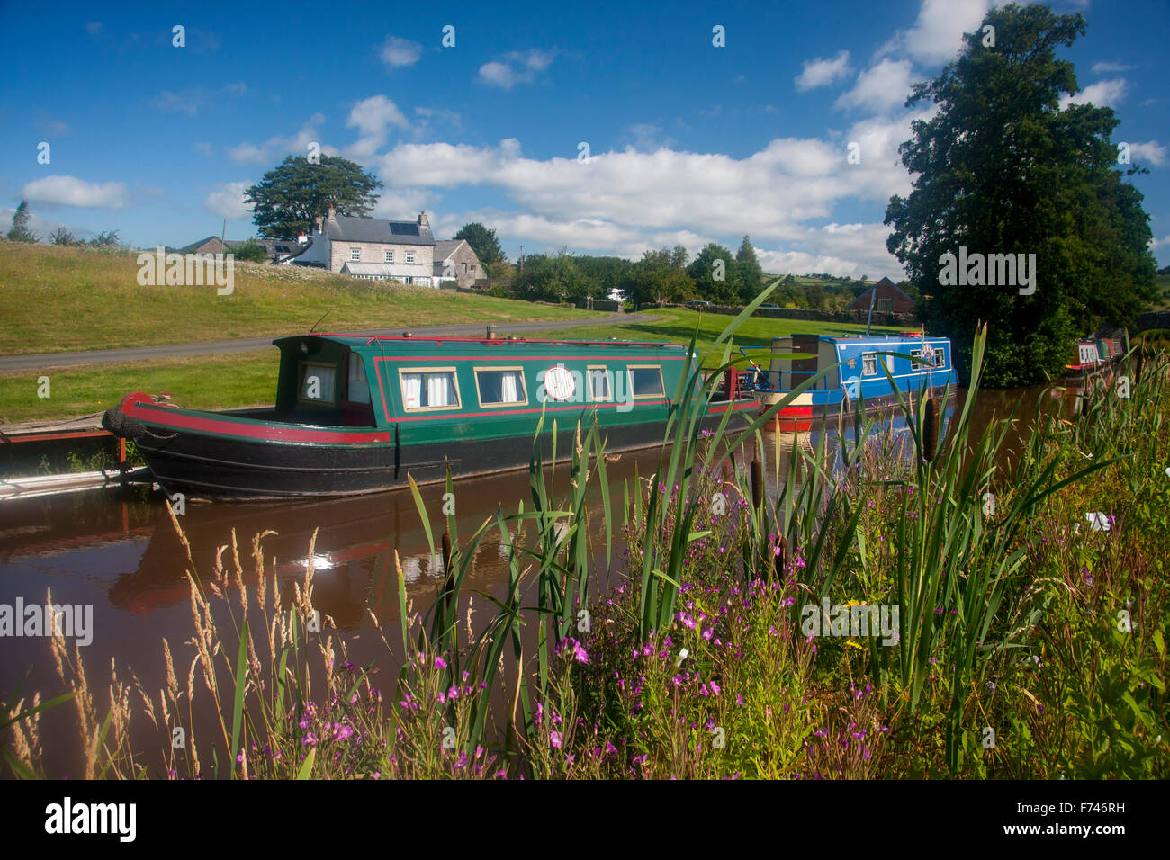 Monmouthshire & Brecon Canal Boote vertäut am Pencelli Haus oder Bauernhaus im Hintergrund Powys Wales UK Stockfoto