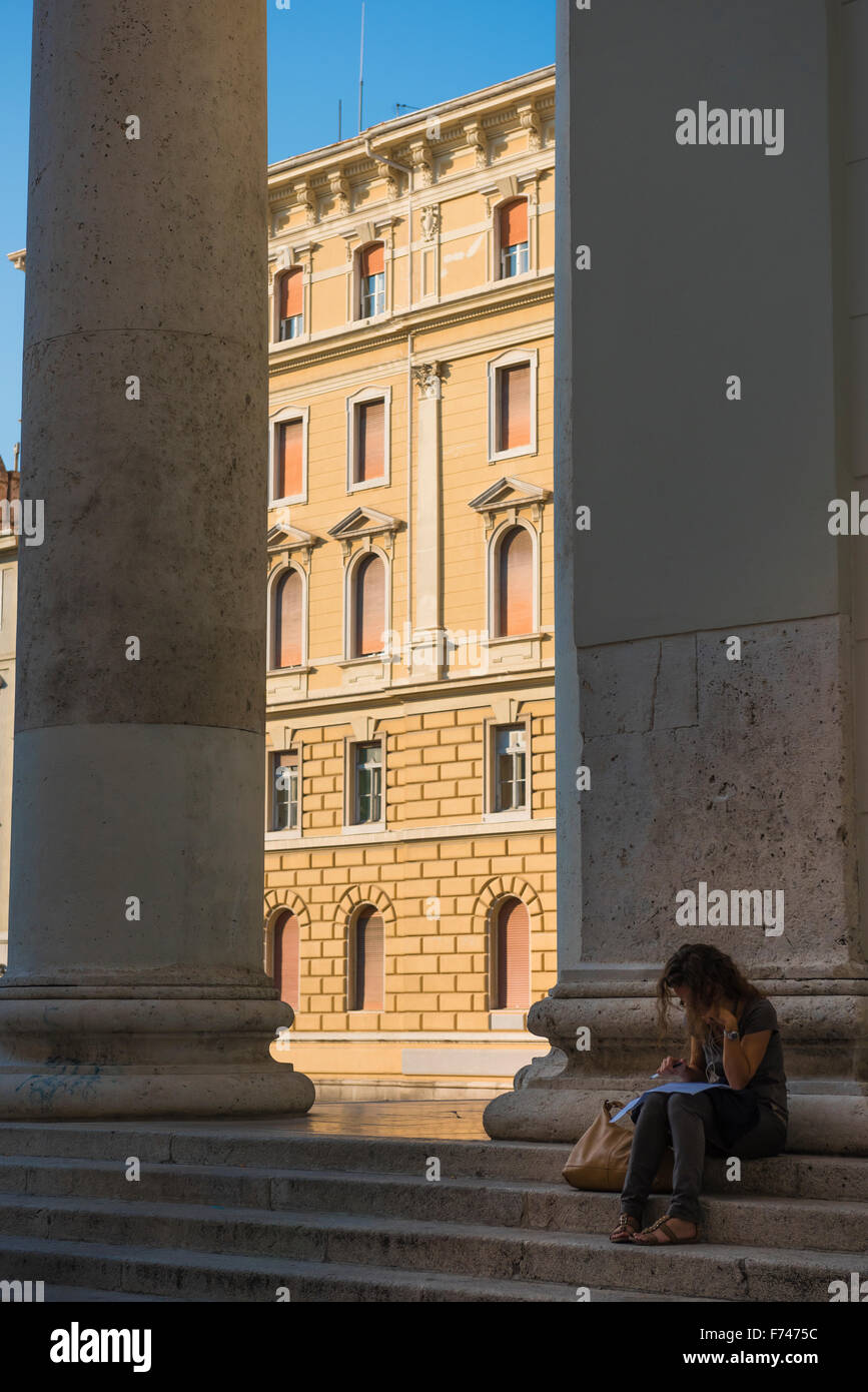 Frau im Schatten sprechen über Ihr Telefon auf den Stufen der Kirche des Hl. Antonius Taumaturgo in Triest, Italien. Stockfoto
