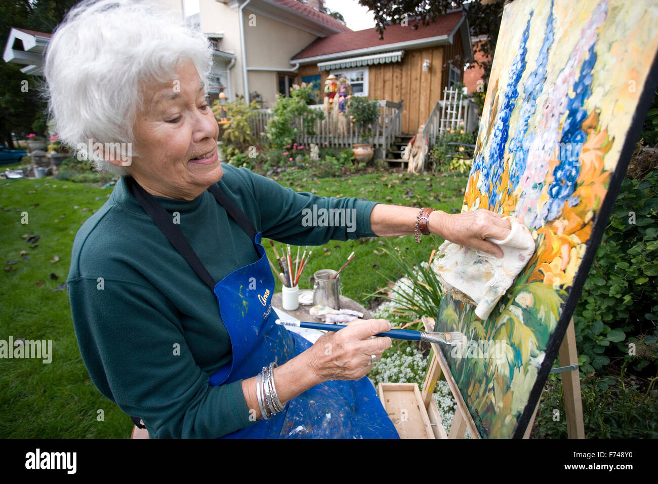 ältere Künstler Malerei im Garten Stockfoto