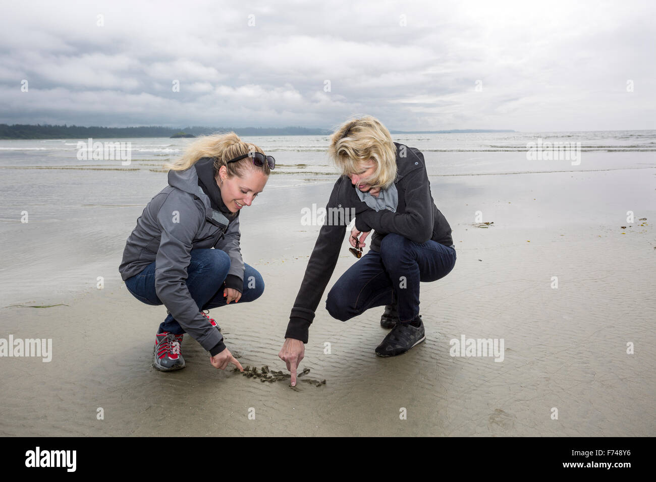 Kanada, British Columbia, Vancouver Insel, Pazifik, Pacific Rim National Park Reserve, 2 Frauen schreiben in sand Stockfoto