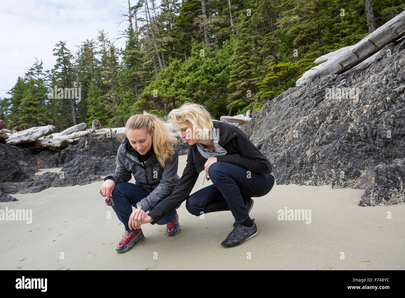 Kanada, British Columbia, Vancouver Island, Pacific Rim National Park Reserve, 2 Frauen suchen bei shell Stockfoto