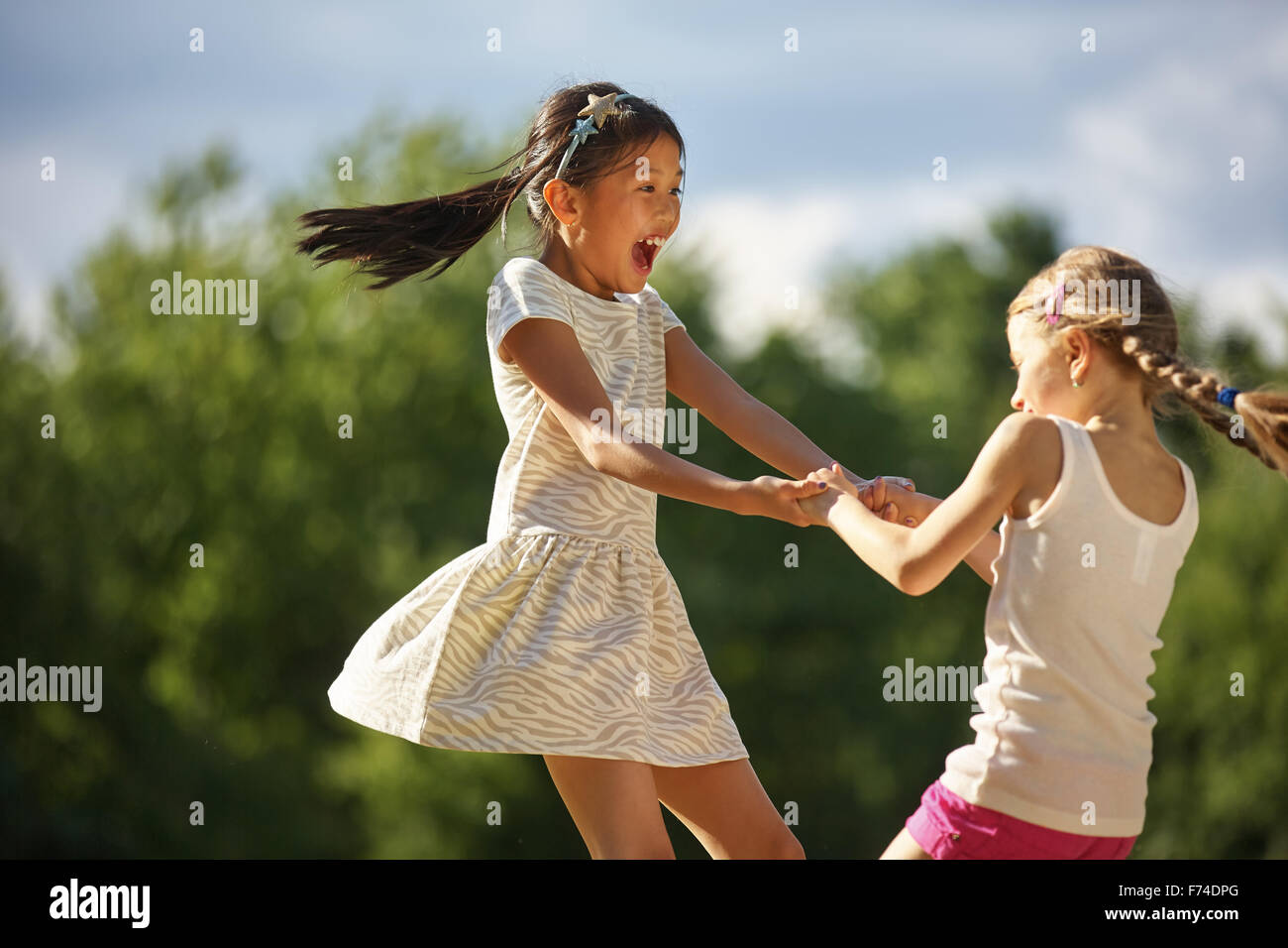 Zwei glückliche Mädchen tanzen in einem Kreis Spaß im Sommer Stockfoto