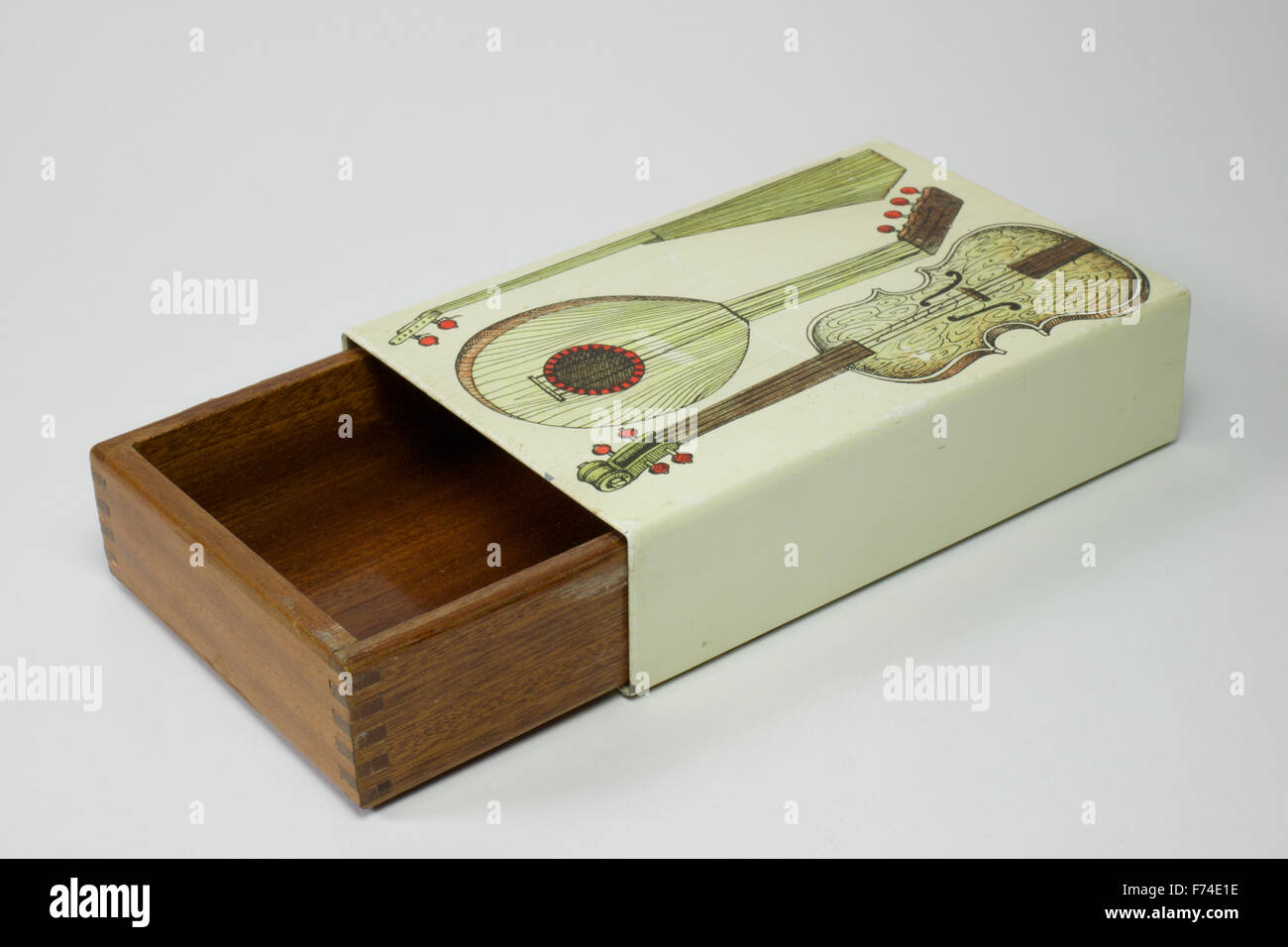 Fornasetti Box mit Schiebetüren Mahagoni innen, oben mit drei Musikinstrumenten dekoriert. Die Box misst 14cm x 9cm und ist Stockfoto