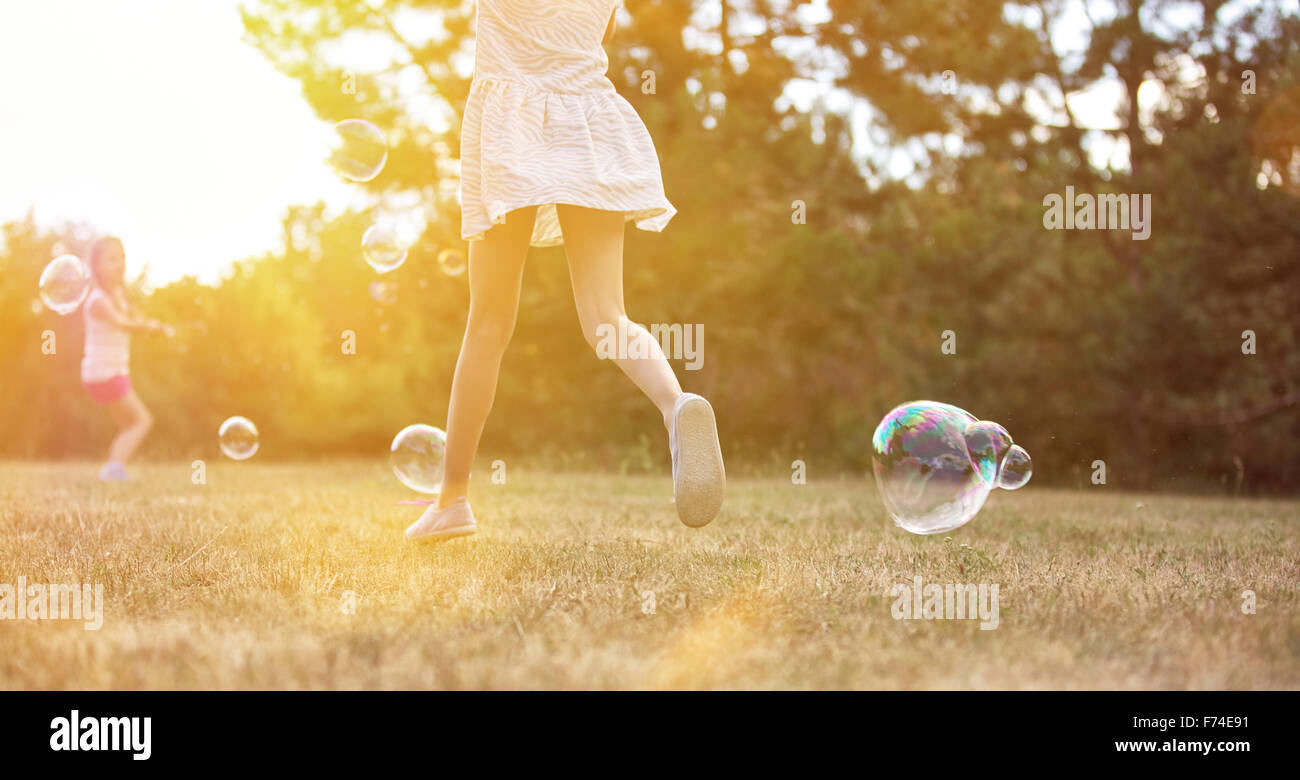 Kinder spielen mit Luftblasen im Sommer in der Natur Stockfoto