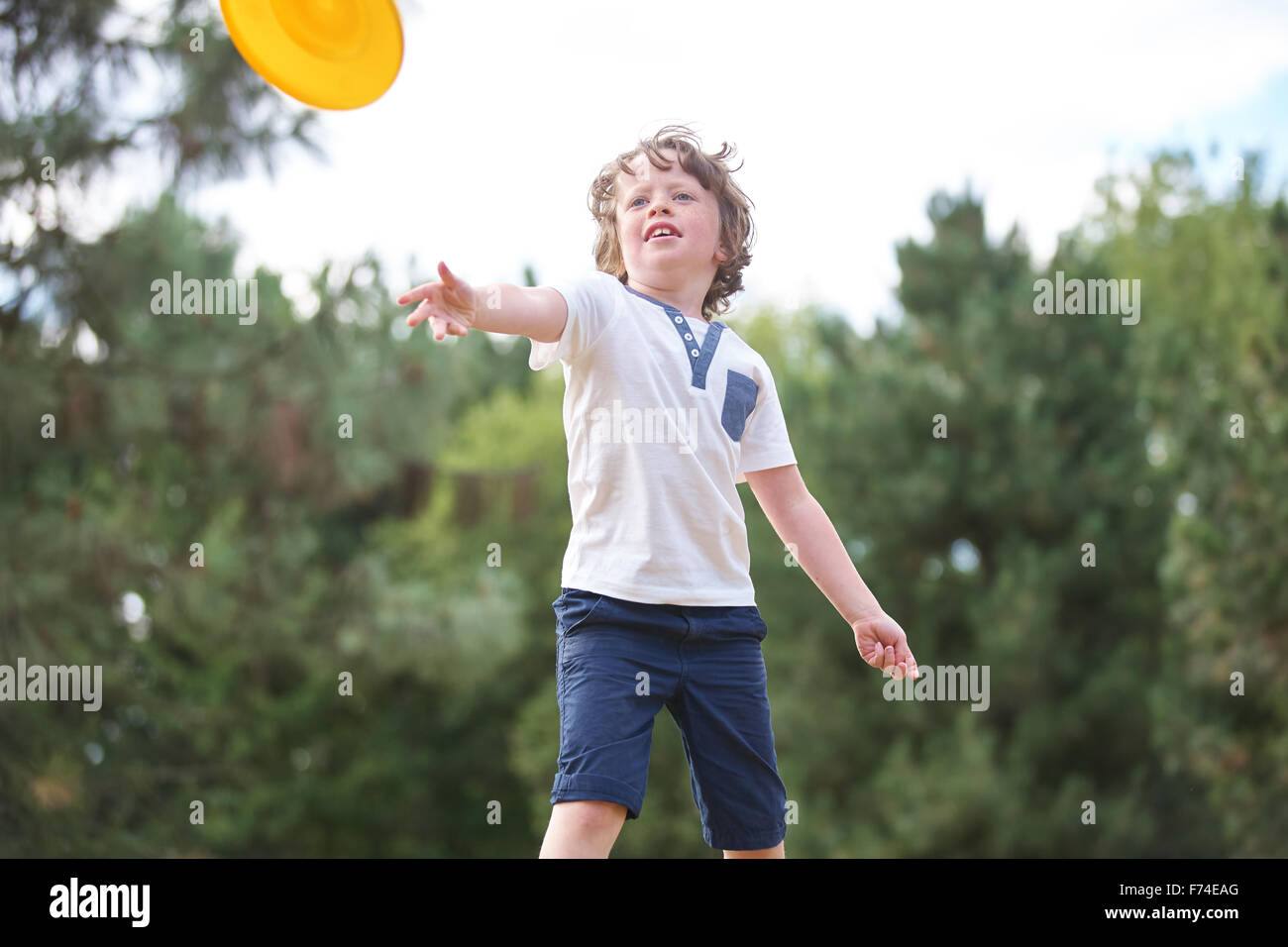 Junge wirft Frisbee im Sommer in der Natur Stockfoto