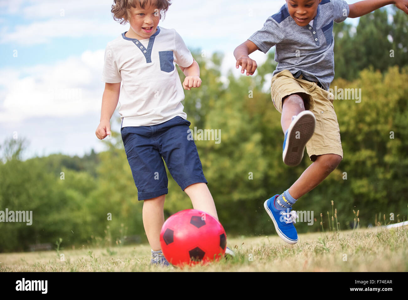 Kinder spielen Fußball und Spaß im Sommer Stockfoto