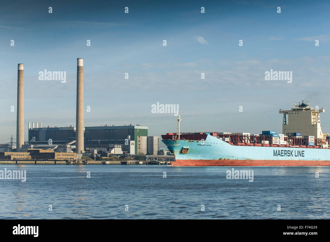 Das große Containerschiff Maersk Lota übergibt Tilbury B Kraftwerk wie Dämpfe flussaufwärts an der Themse. Stockfoto