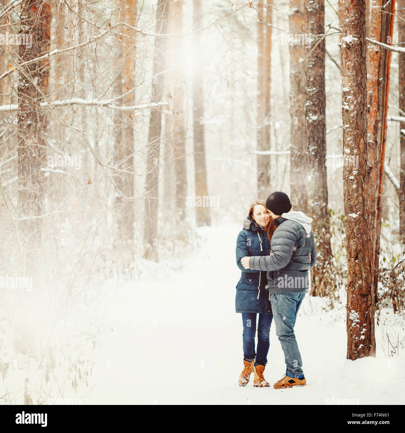 Junges Paar umarmt im Winterwald. Winterurlaub. Wochenendausflug. Platz für Text. Natürliche Farben, selektiven Fokus. Stockfoto