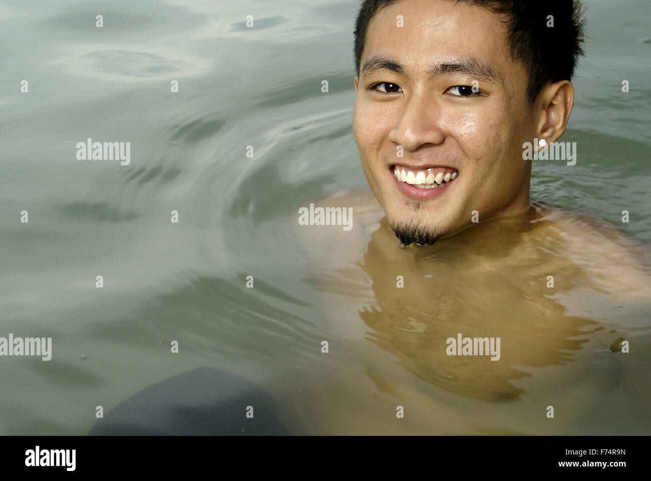 Lächelnd asiatischen Mann im Seewasser Stockfoto