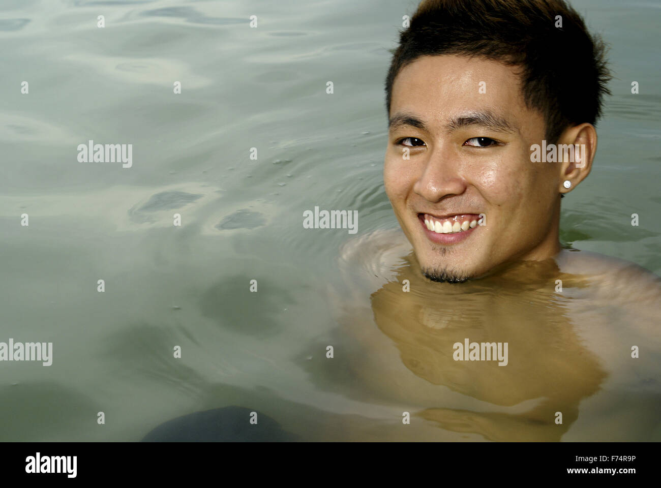 Lächelnd asiatischen Mann im Seewasser Stockfoto