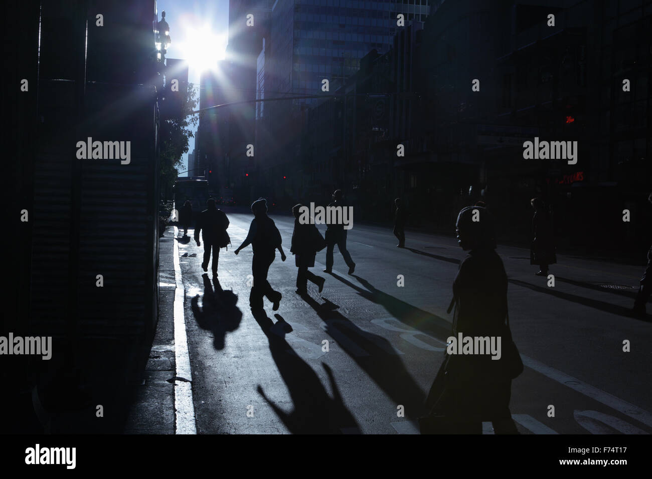 Blaue Schatten und Silhouetten von unkenntlich Menschen hinunter 34th Street in New York City bei Sonnenaufgang Stockfoto