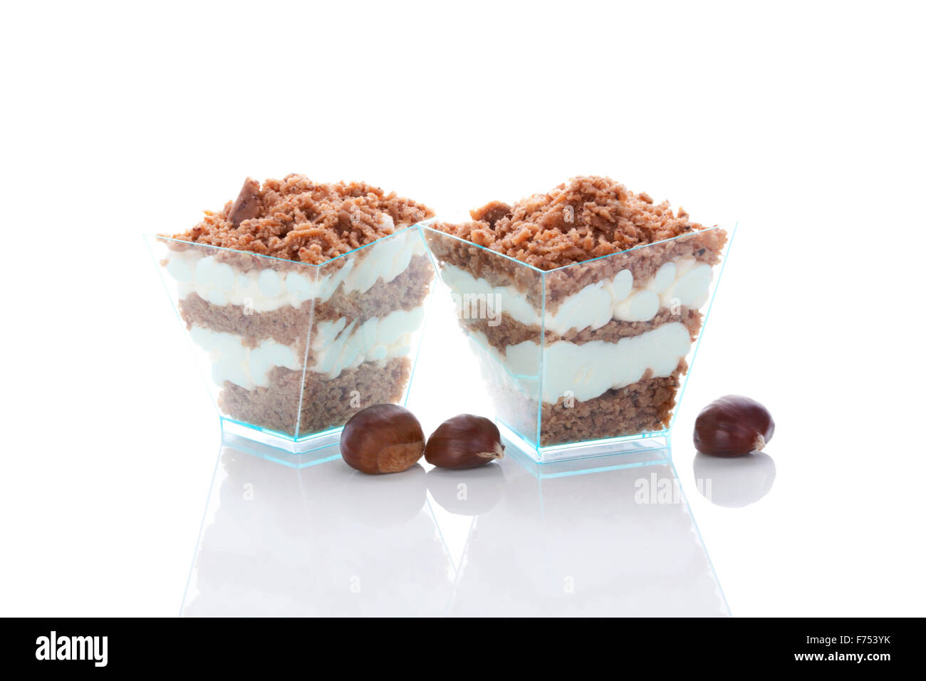Kastanien Püree-Dessert im Glas und Kastanien isoliert auf weißem Hintergrund. Kulinarischen Süßspeise zu essen. Stockfoto