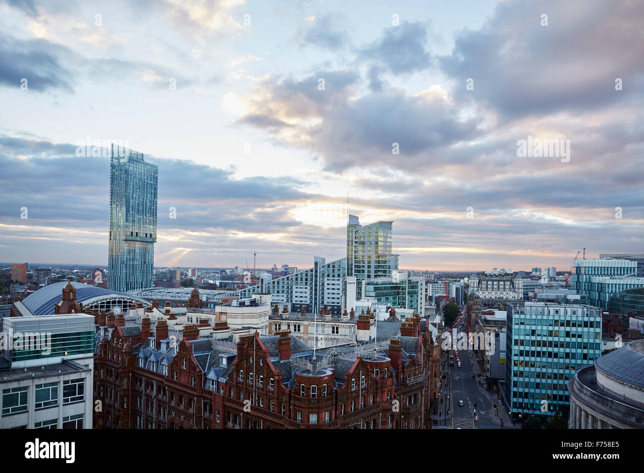 Manchester Skyline zeigen sich die Dächer der Spiele g-Mex zentrale Betham Turm Lichtschacht Strahlen durch die Wolken Sonnenuntergang Dämmerung niedrigen ligh Stockfoto