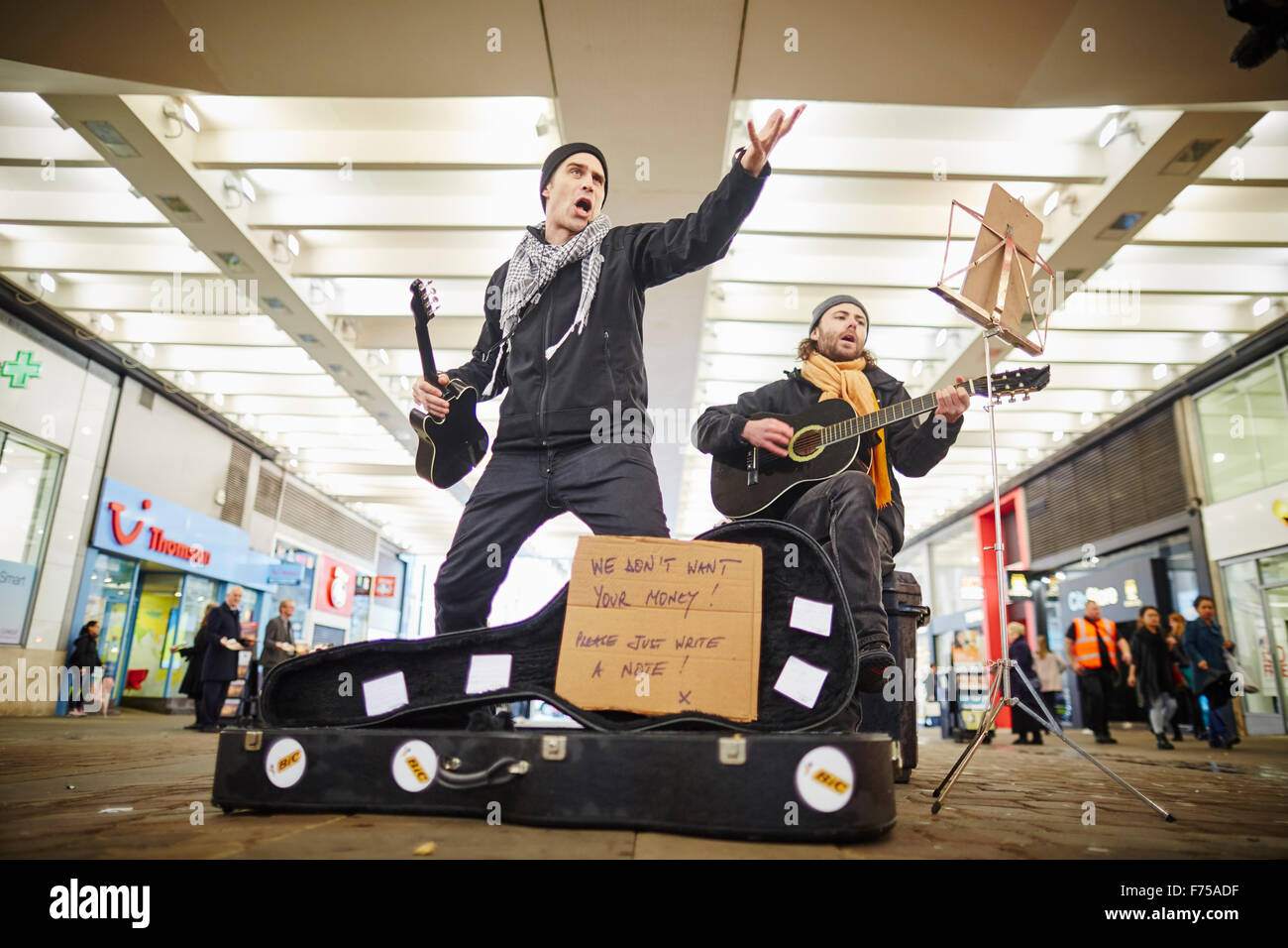 Straßenmusik Buskers Leistung durchführen Performer unterhaltsames Passanten Massen singen Karte kein Geld zwei shopping Bereich shop Stockfoto