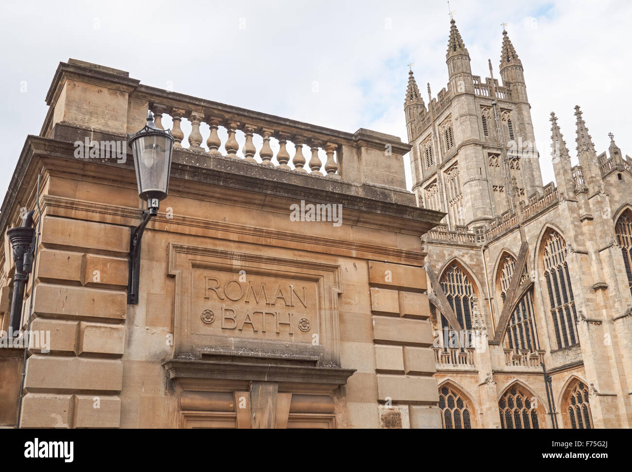 Stein gehauen Schild an die Roman Baths mit der Abteikirche von Bath im Hintergrund, Bath Somerset England Vereinigtes Königreich Großbritannien Stockfoto