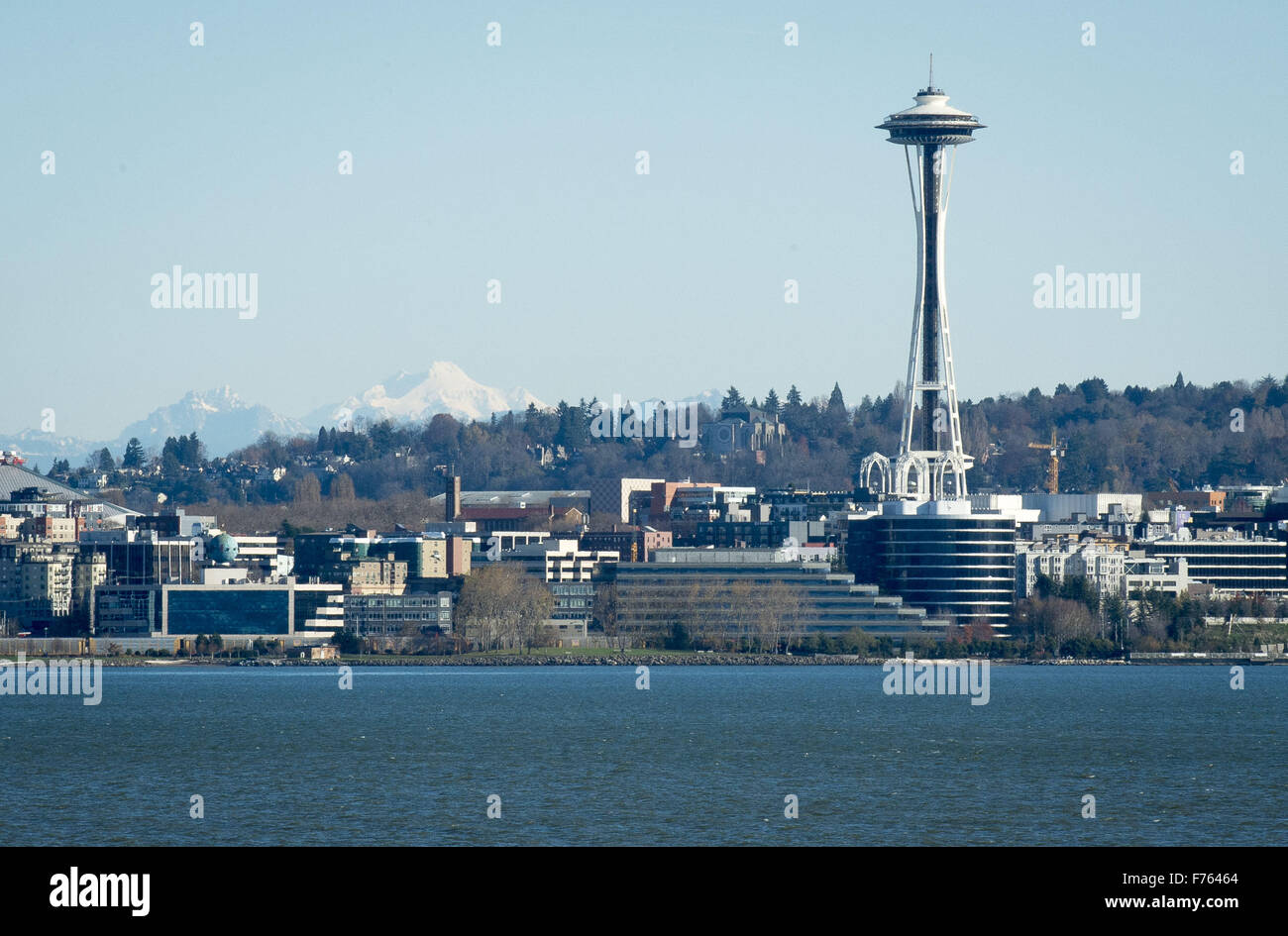 Seattle, Washington, USA. 21. November 2015. Seattle Space Needle, Seattle Center liegt an Bord einer Washington State Ferry in dieser Ansicht, Blick nach Osten über den Gewässern der Elliott Bay im Puget Sound entnehmen. Die Space Needle, bei über 605 Fuß hoch, wurde vom Hotelier Edward E. Carlson und Architekten John Graham Jr. entworfen und gebaut von Auftragnehmer Howard S. Wright für die 1962 Welten Fair. Errichtet um 200 mph Winden und ein 9.1 Erdbeben zu widerstehen, die Space Needle verfügt über eine Aussichtsplattform und ein Drehrestaurant. Glacier Peak, sehen im Osten in der Cascade Mountain Range Stockfoto