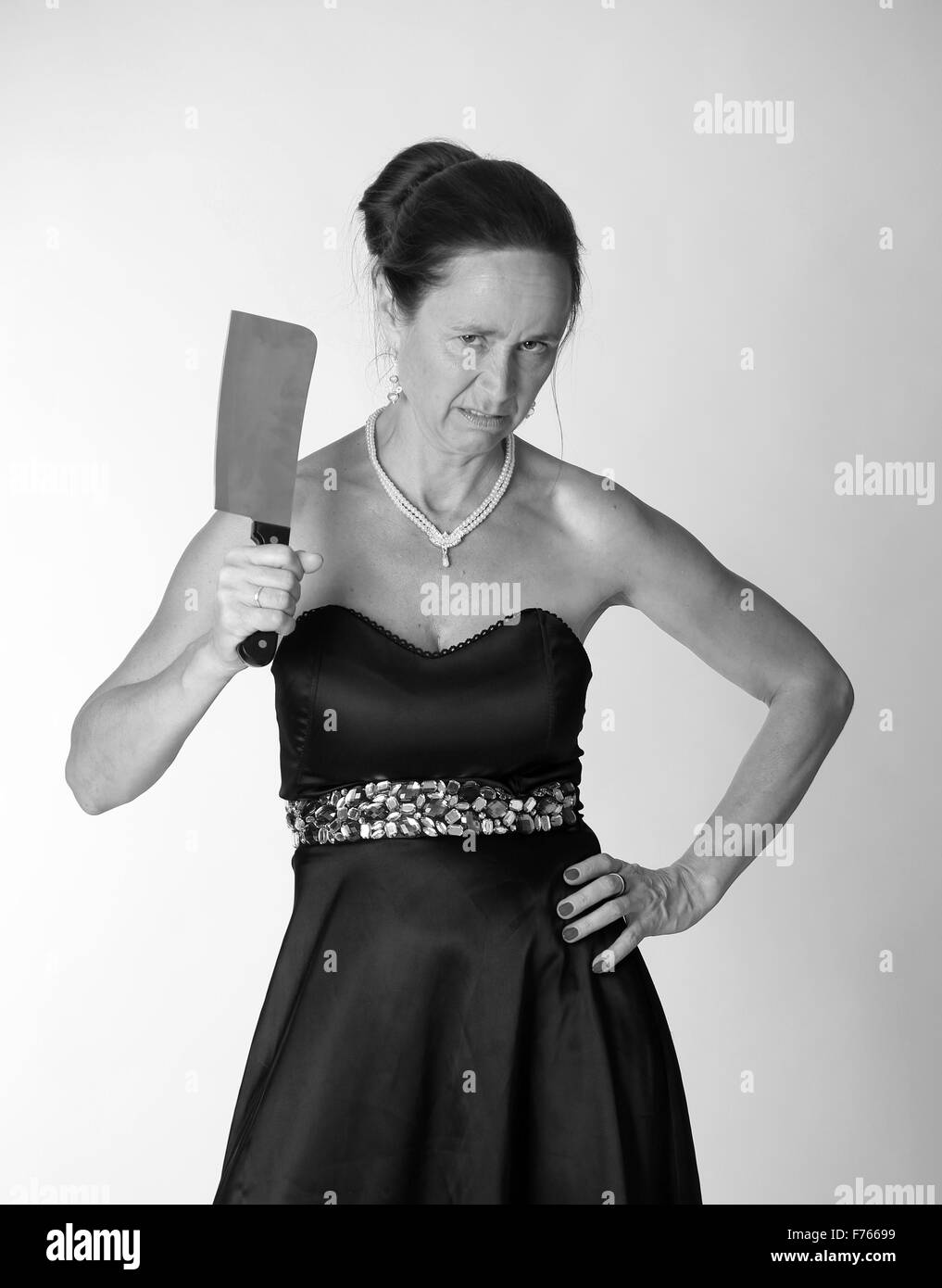 Verrückte Reife Frau mit einem großen Messer / Fleischerbeil Stockfoto