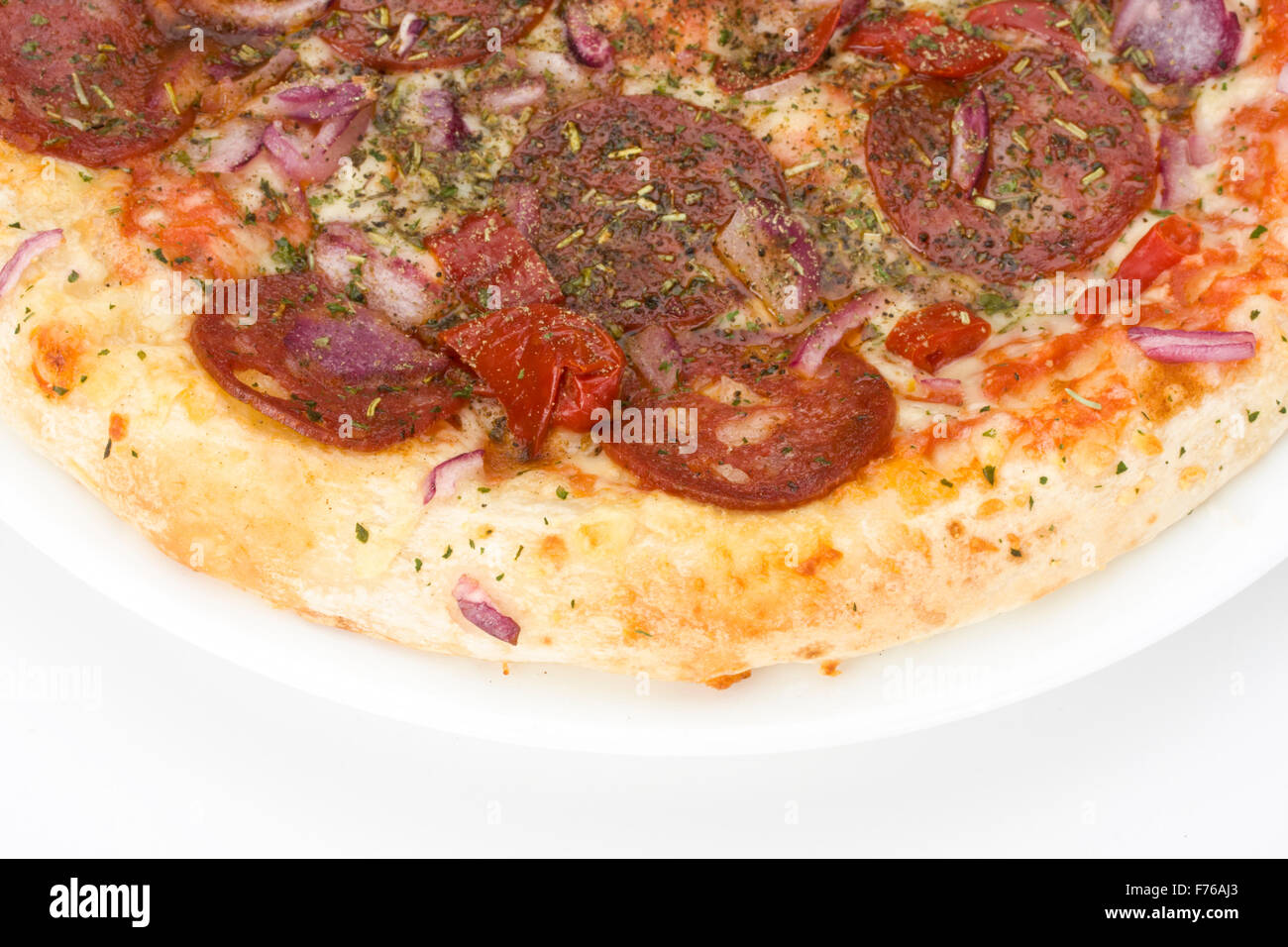 eine Pizza auf einem weißen Teller über hellen grauen Hintergrund Stockfoto