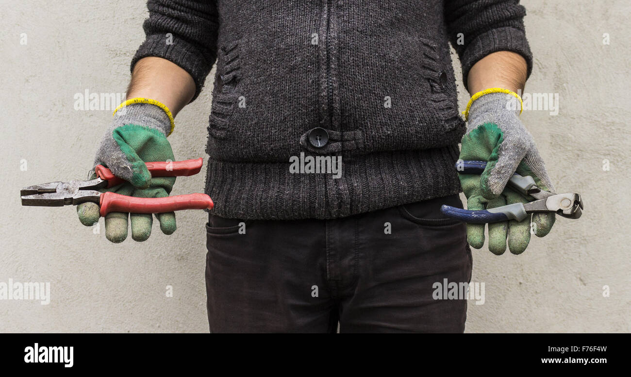 Zange gehalten von einem arbeitenden Menschen Stockfoto