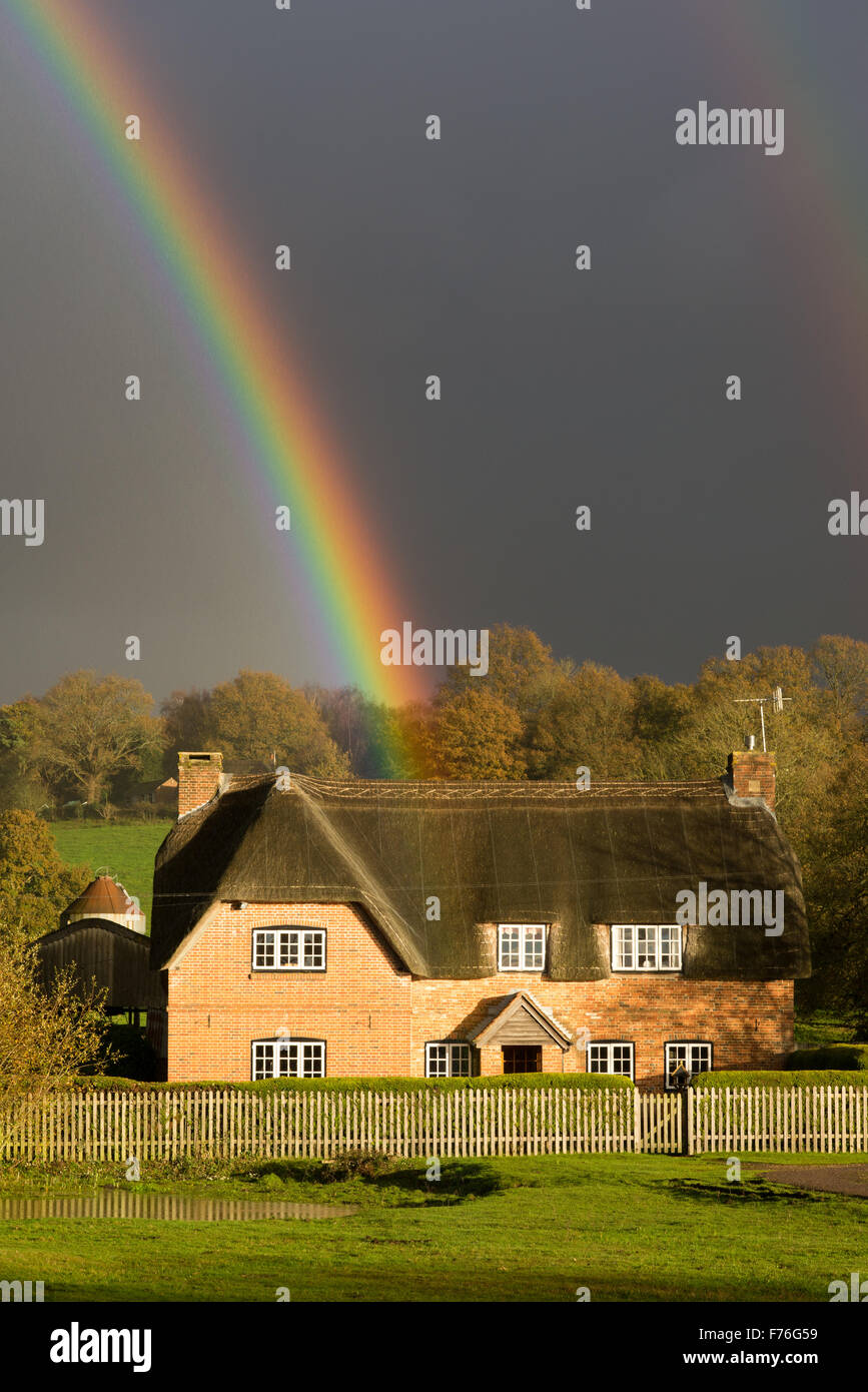 Regenbogen über reetdach Ferienhaus in den New Forest, Hampshire, Großbritannien Stockfoto