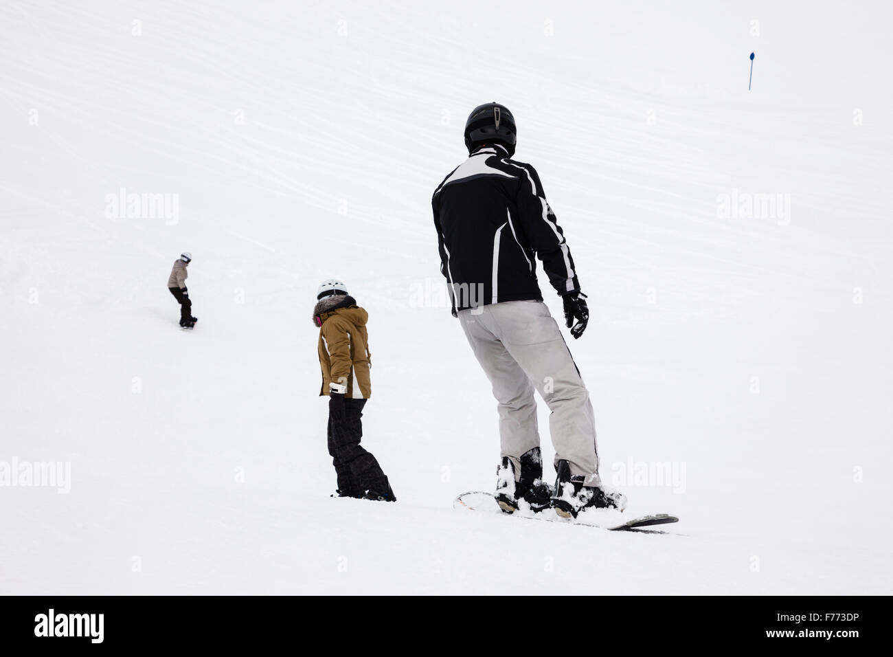 Snowboarder einsteigen hinunter Schnee bedeckt Skipisten in den österreichischen Alpen. St. Anton am Arlberg, Tirol, Österreich, Europa. Stockfoto