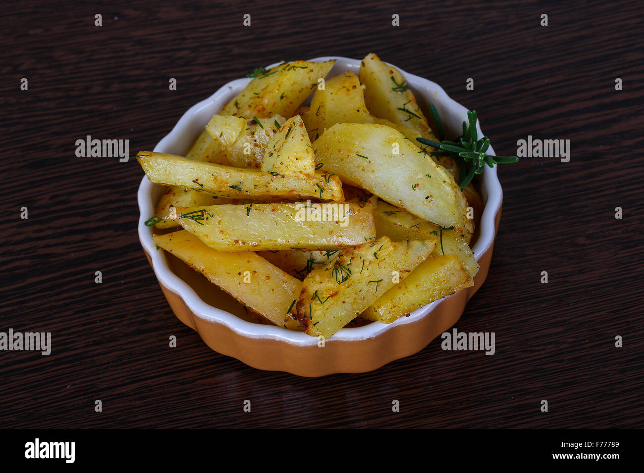 Geröstete Kartoffeln mit Dill und Rosmarin auf dem Holz Hintergrund ...