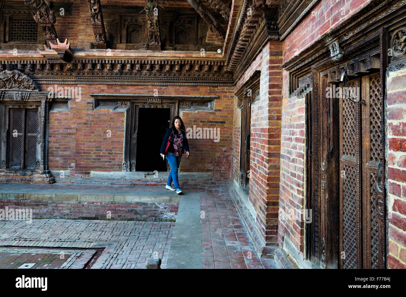 eine Dame, die zu Fuß aus Patan Durbar Square Museum, Patan, Lalitpur, 2015, Nepal Stockfoto