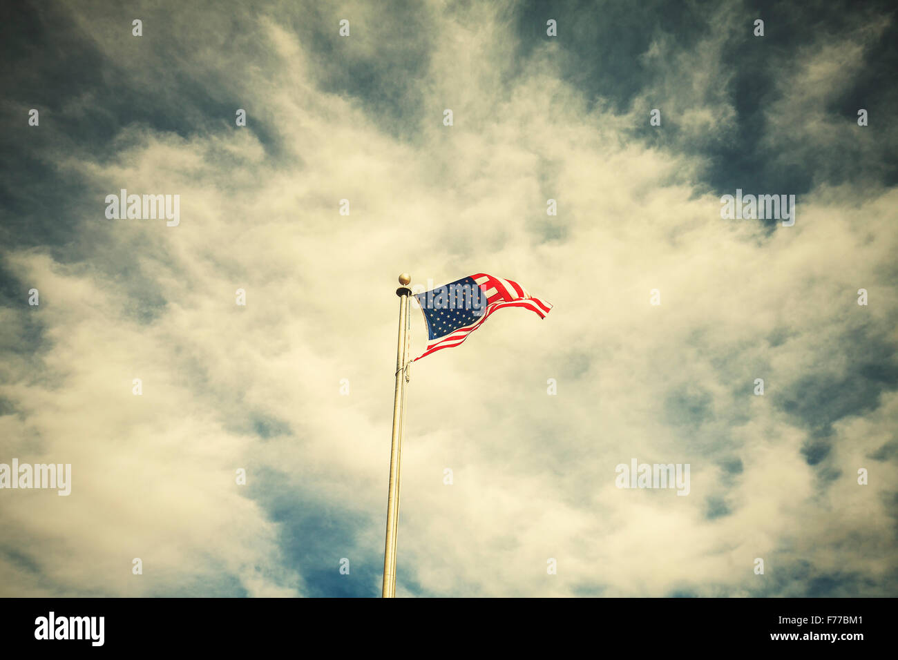 Retro getönten amerikanische Flagge am bewölkten Himmel. Stockfoto