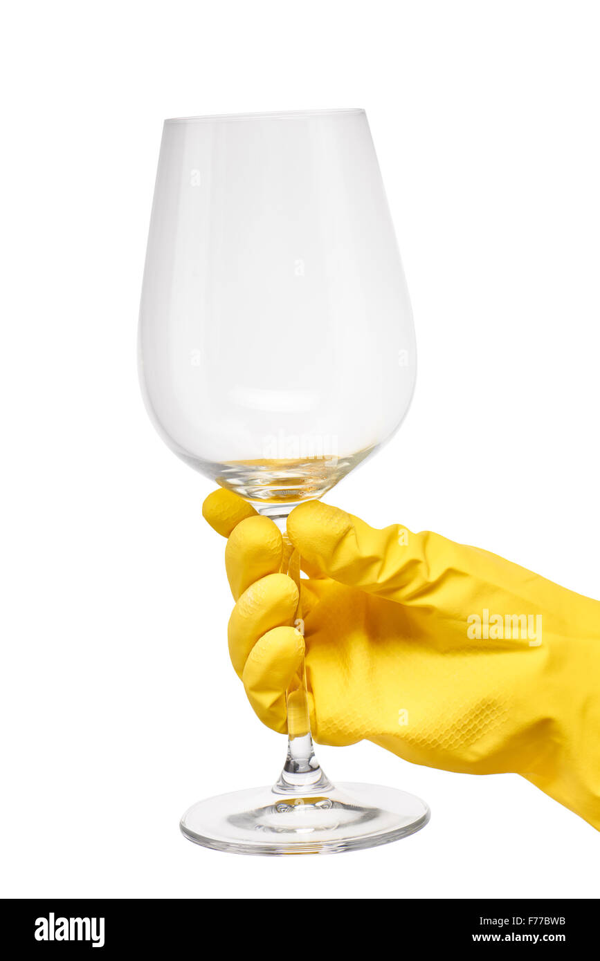 Nahaufnahme des weiblichen Hand in gelben schützende Gummihandschuh hält sauber transparentes Glas Wein vor weißem Hintergrund. Stockfoto