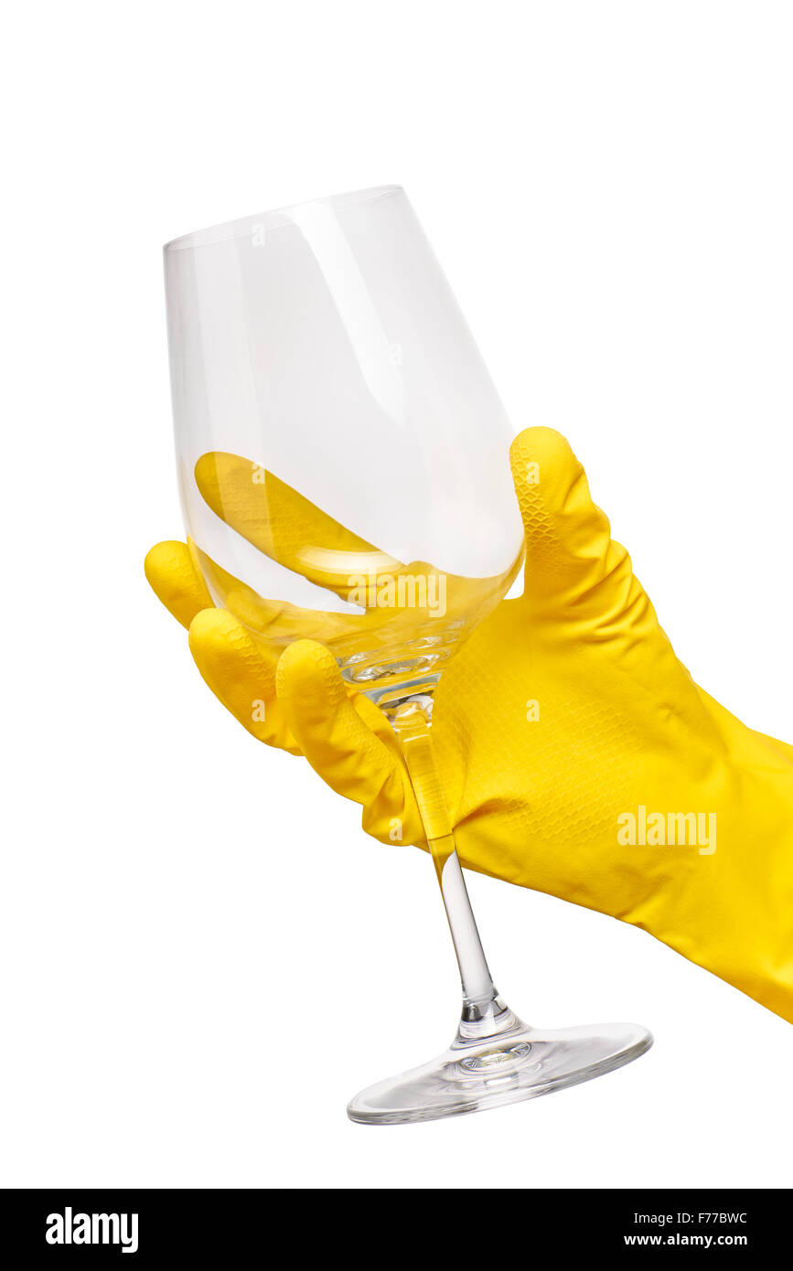 Nahaufnahme des weiblichen Hand in gelben schützende Gummihandschuh hält sauber transparentes Glas Wein vor weißem Hintergrund. Stockfoto