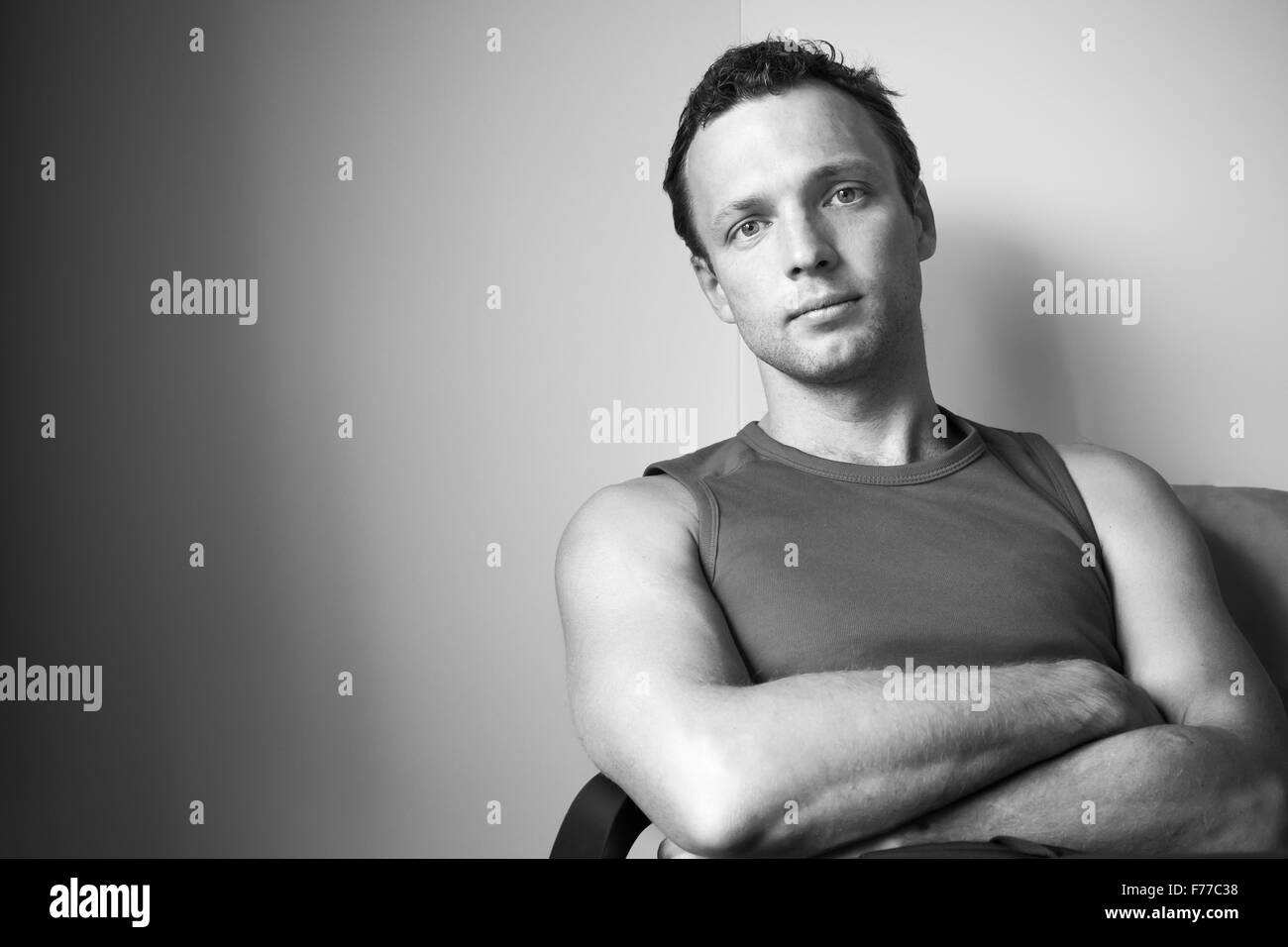 Monochrome Studioportrait von entspannenden sportlichen kaukasischen Jüngling im Hemd Stockfoto