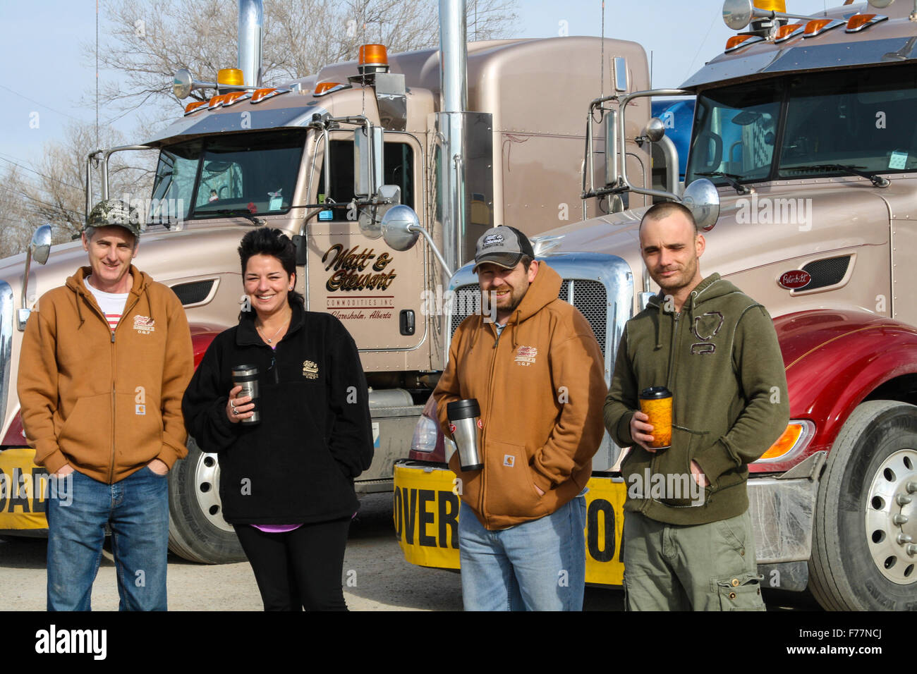 Ausländische LKW-Fahrer posieren neben ihre "Watt und Stewart" kanadische Firma Peterbilt Trucks in Dalhart, Texas, USA Stockfoto