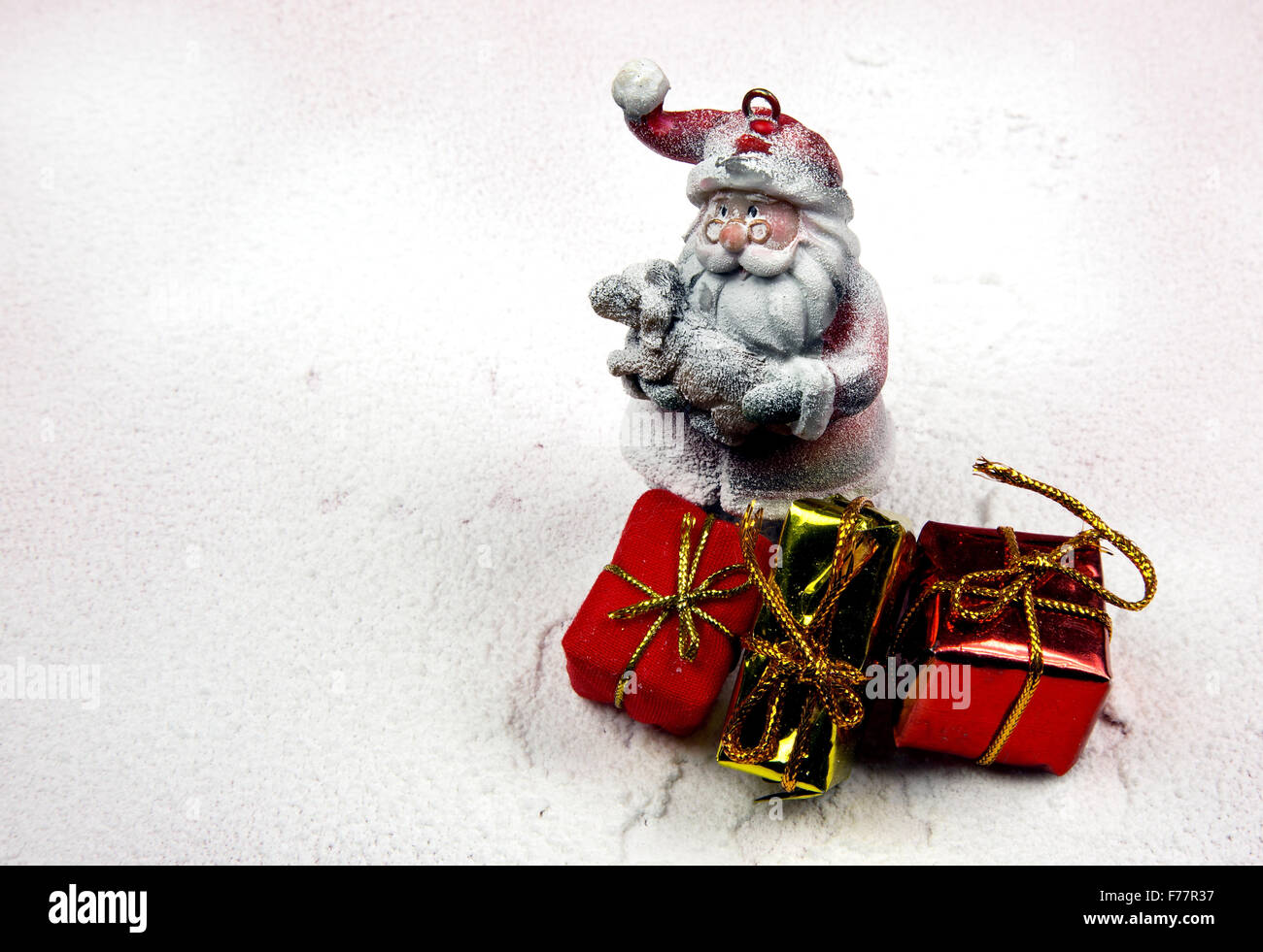 Weihnachten Dekoration, verschneiten Figur des Weihnachtsmannes in seinen Armen hielt, ein kleines Lamm und drei dekorative Geschenke. Horizontale Ansicht. Stockfoto