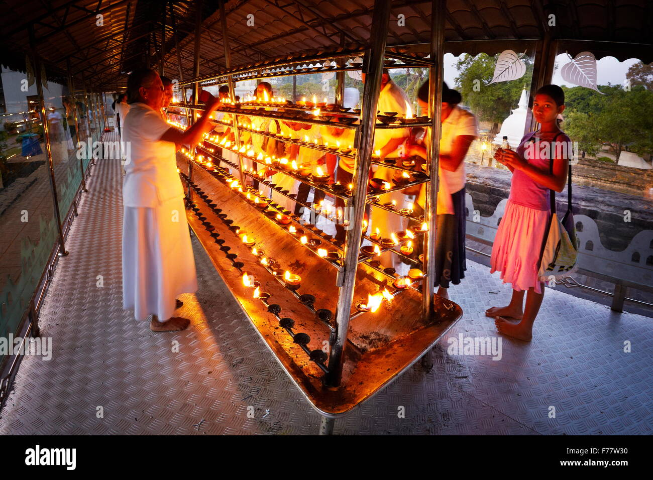 Sri Lanka, Kandy - Pilger Leuchten Kerzen im Tempel des Zahns, Sri Dalada Maligawa, UNESCO-Weltkulturerbe Stockfoto
