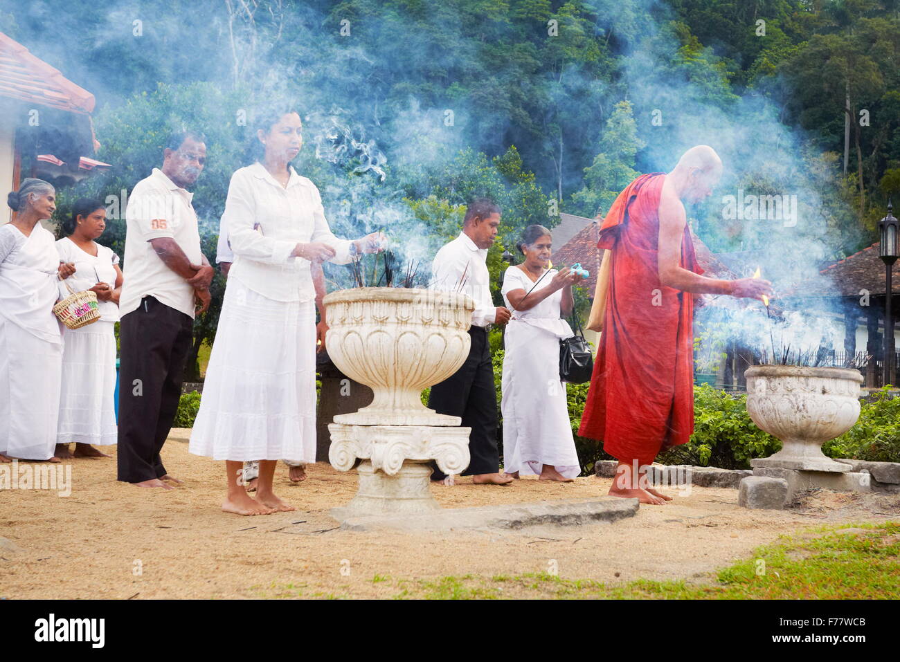 Sri Lanka, Kandy - Mönch Leuchten Angebote der Weihrauch im Tempel des Zahns, Sri Dalada Maligawa, UNESCO-Weltkulturerbe Stockfoto