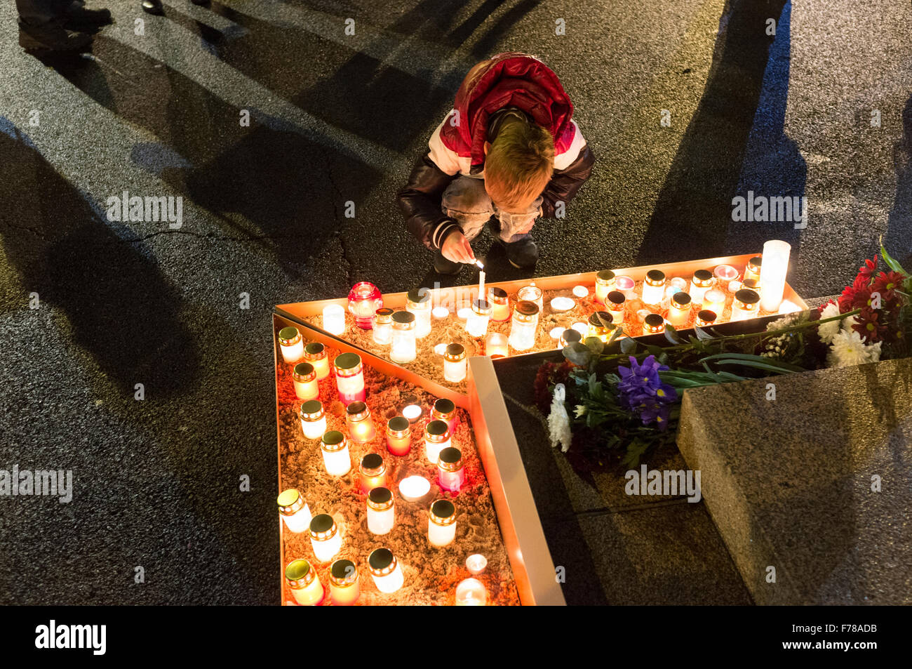 Riga, Lettland. Eine junge Lichter Kerzen unter dem Freiheitsdenkmal auf Lacplesa Tag zu begehen. Lāčpleša Tag feiert man jedes Stockfoto