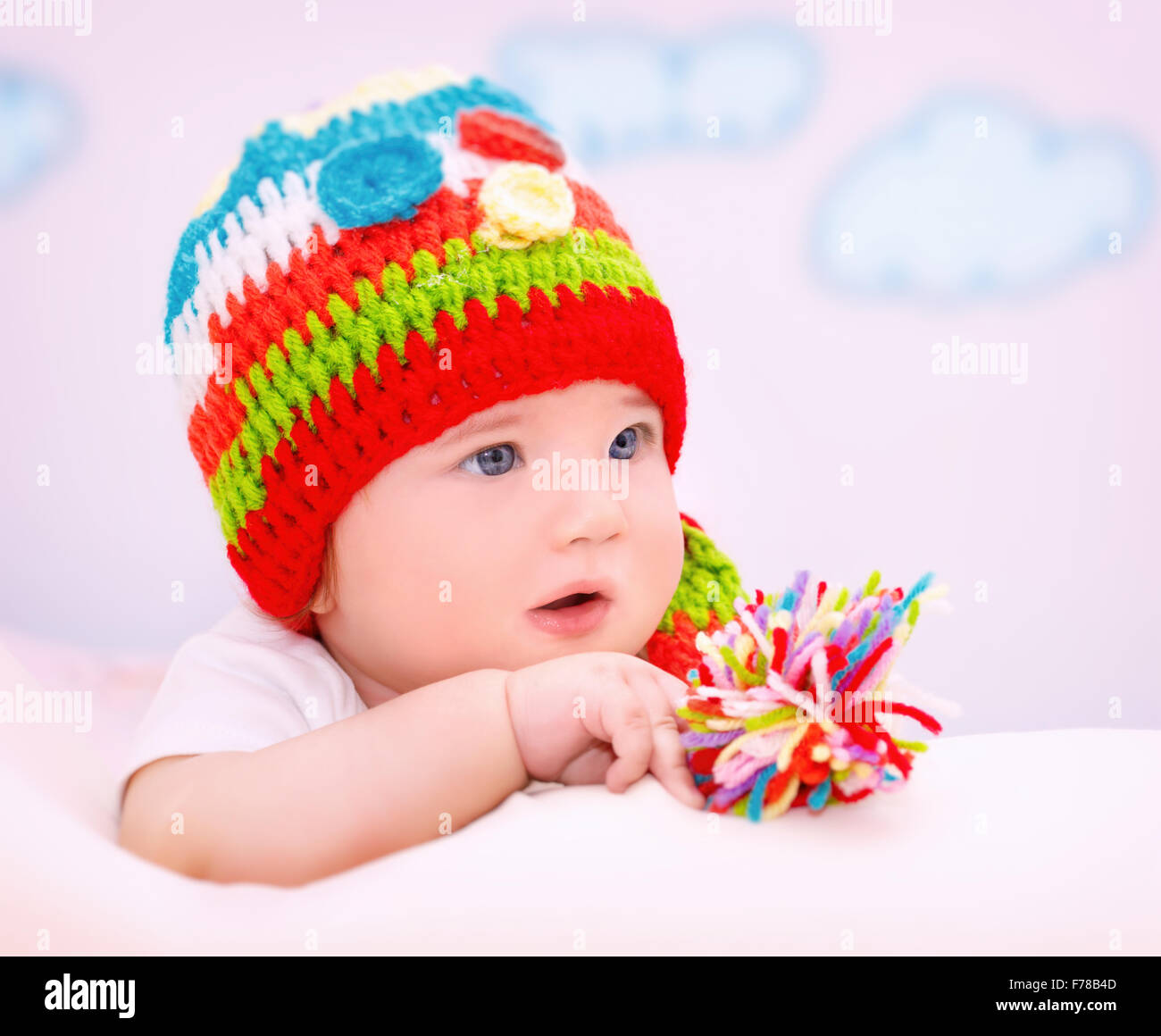 Porträt von niedlichen kleinen Baby tragen bunte Mütze entspannend in gemütlichen Kinderzimmer, gesunde Lebensweise, glückliches Kind sorglos Stockfoto