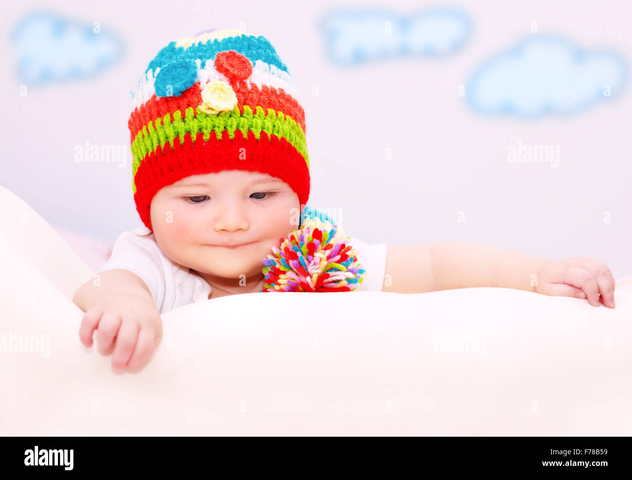 Porträt von niedlichen kleinen Baby tragen bunte Mütze entspannend in gemütlichen Kinderzimmer, gesunde Lebensweise, glückliches Kind sorglos Stockfoto