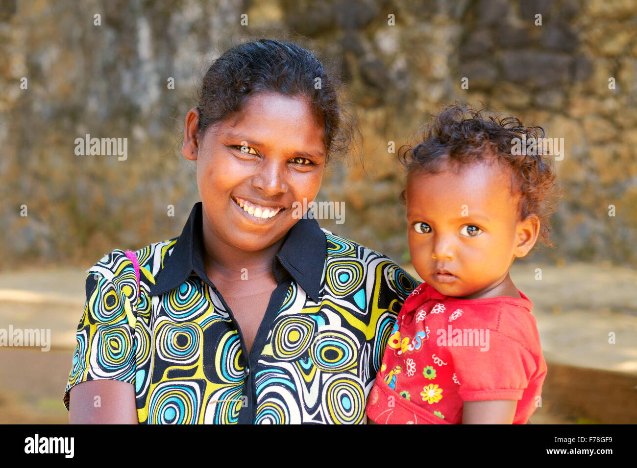 Sri Lanka – Porträt von Sri Lanka junge lächelnde Frau mit ihrem Baby Kind Stockfoto