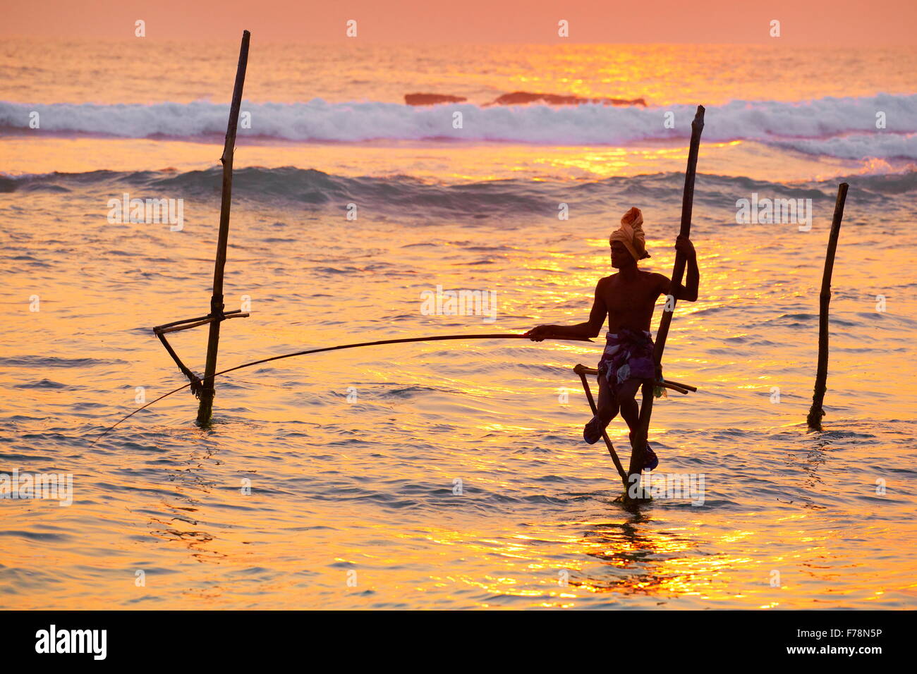 Tropischen Meer Landschaft mit Stelzen Fischer bei Sonnenuntergang, Koggala Beach, Sri Lanka, Asien Stockfoto