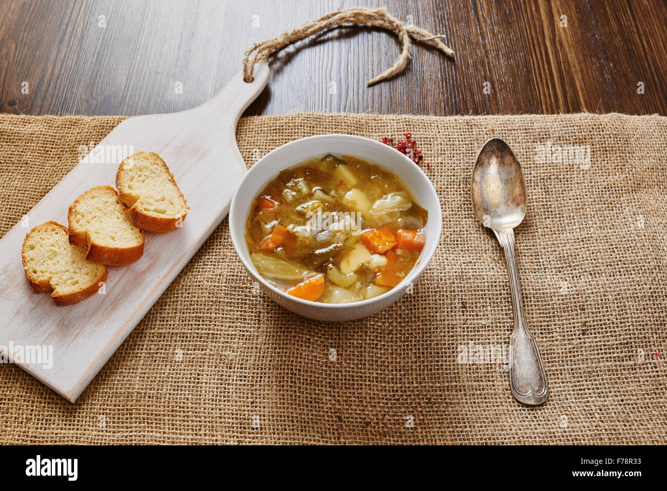 Gemüsesuppe in weiße Schüssel auf dunklen Holztisch Stockfoto