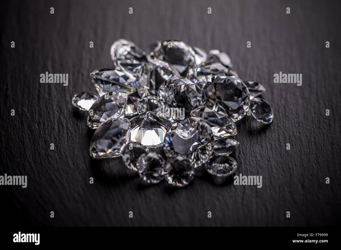Haufen von Diamanten auf dunklen Metalloberfläche Stockfoto